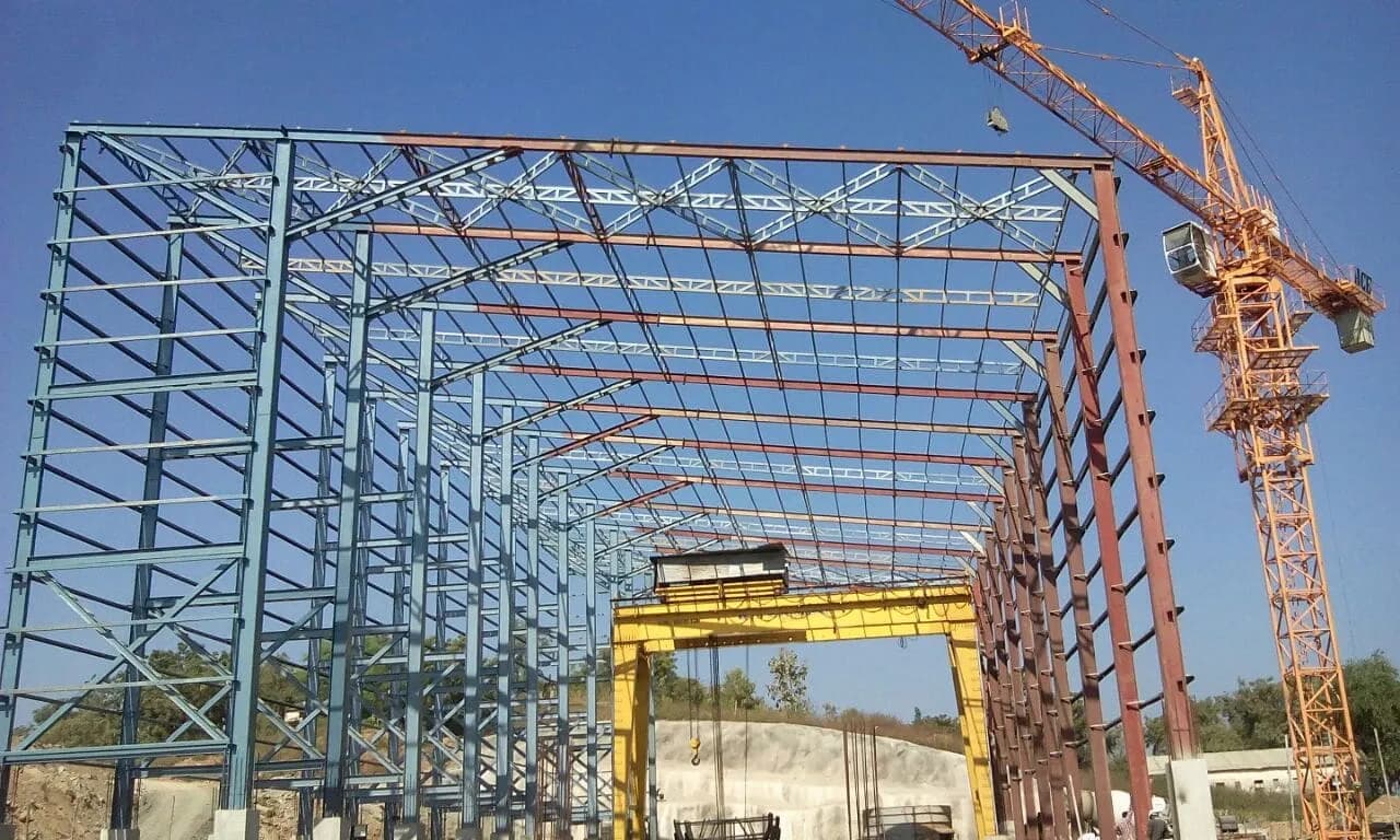 Pre-engineered steel portal frame under erection on site