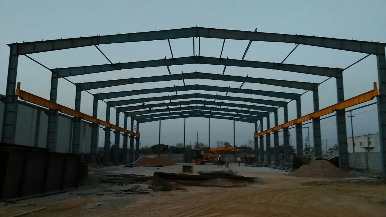 Steel portal frame during erection at dusk
