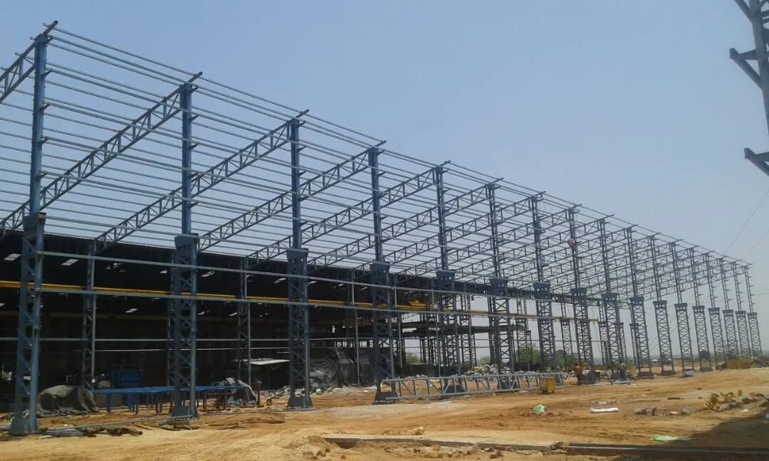 Large multi-bay steel truss frame under erection