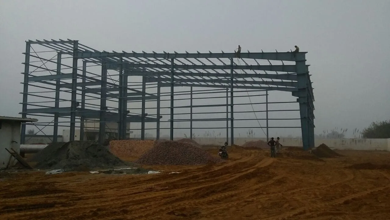 Steel building frame under erection in morning fog